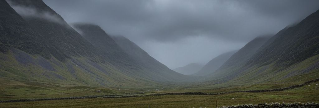 A wide U-shaped valley under a low grey overcast, steep grass-covered slopes either side, dry-stone walls crossing the moor